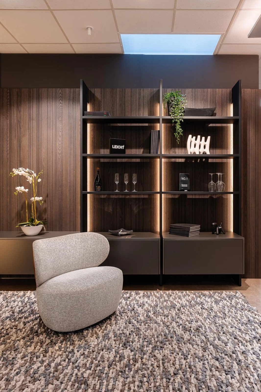 Inszeniertes Interior mit Regal, sanfter Beleuchtung und ausgewählten Wohnaccessoires